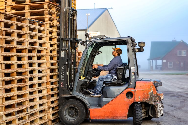 Forklift with large stack of block pallets
